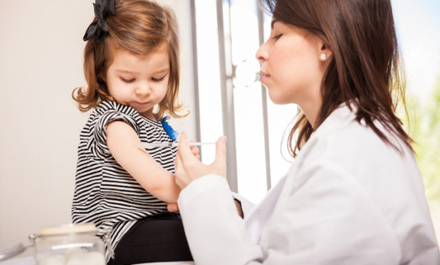 Pediatrician giving a girl a shot